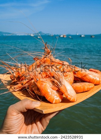 Steamed shrimps on white plate with sea background. Seafood dish. The above picture of shrimp or prawn That was made by steaming or boiling or baking looks delicious and ready to be eaten.