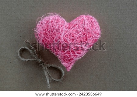 Heart shape made of pink material fabric on a rustic natural background with copyspace. Concept of Valentine's day and romantic love.