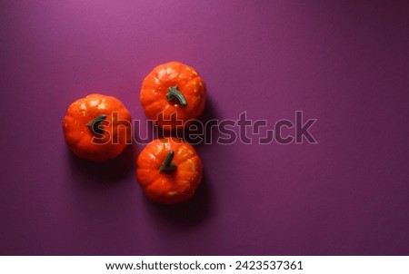 Plastic Halloween pumpkins on purple background. Top view
