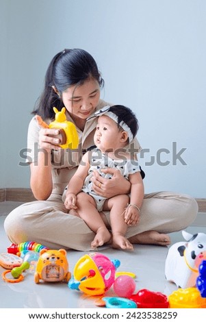 Mother and child playing with children's toys in the house,Mother and child are on the floor in the living room and play with her little child. 