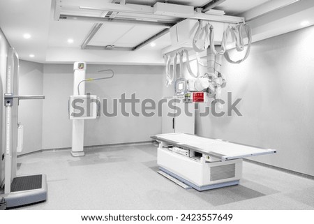 Modern x-ray machine and Computerized Axial Tomography scanning and medical equipment.  Radiology room with scan machine with empty bed. X-ray room with modern X-ray machine in hospital. Royalty-Free Stock Photo #2423557649
