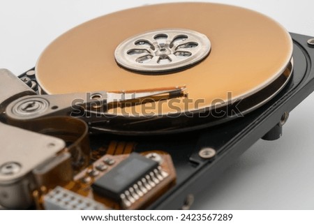 HDD, Hard disk drive, circular magnetic disk, platters. Central spindle, actuator arm with read write head. Circuit board. Mechanical and electronic components. Precision device for data storage.