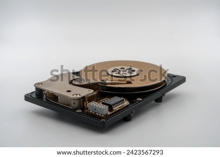 Hard disk drive (HDD), circular magnetic disk, platters. Central spindle, actuator arm with read write head, circuit board. Precision device for data storage, mechanical and electronic components
