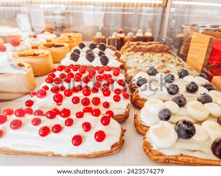Sweet pastries with berries. Clouse-up of freshly baked cakes and cupcakes in a row at food market