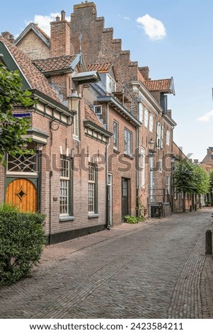 Narrow old street with wall houses in the old part of Amersfoort. Royalty-Free Stock Photo #2423584211