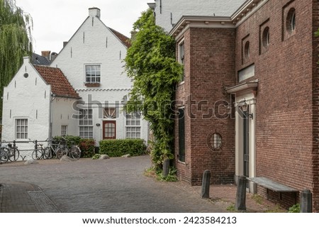 Narrow old street with wall houses in the old part of Amersfoort. Royalty-Free Stock Photo #2423584213