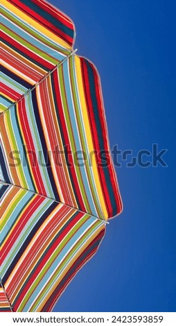 Colorful umbrella in blue sky umbrella blue sky summer sky beach playa cielo azul cielo sombrilla  Royalty-Free Stock Photo #2423593859