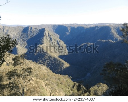 Rugged Mountain Gorge with Dense Vegetation and Shadowy Depths Royalty-Free Stock Photo #2423594037
