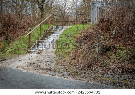 Water flooding down some wooden steps off a railway line due to excessive rain