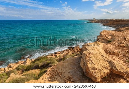 Mediterranean rocky seashore at coast of the Costa Blanca, Torrevieja,  Alicante, Spain. Stunning views of the clear blue sea. Sea landscape with line of horizon