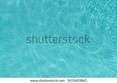 Water surface in a swimming pool, ripple water in tiled swimming pool with sun reflection