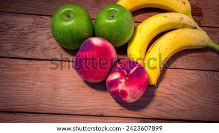 Apple, peach and bananas on a wooden board. Composition of healty fruits.