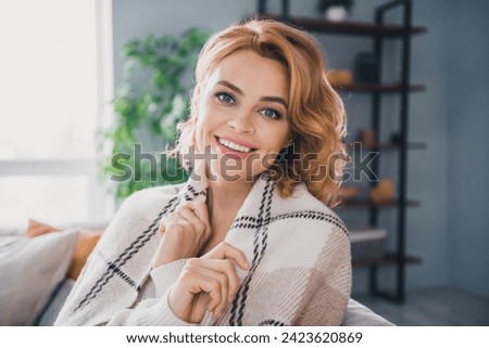 Portrait of pretty satisfied glad person beaming smile sit sofa cover herself warm blanket bright house inside Royalty-Free Stock Photo #2423620869