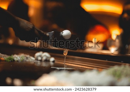In Teppanyaki Japanese cuisine style, chef might juggle utensils, catch an egg in their hat, toss an egg up in the air and split it with a spatula, or flip flattened shrimp pieces into diners' mouths