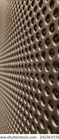 A wall made of iron with a pattern or pattern of holes, a beautiful texture, a good background