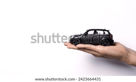 Hand holding a toy car isolated on white background. After some edits. Royalty-Free Stock Photo #2423664431