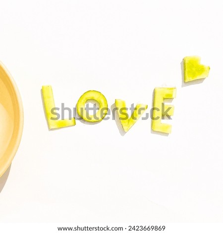 This picture is a background with the word love written on it made from a green type of vegetable.