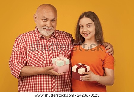 positive girl and granddad with present box for anniversary