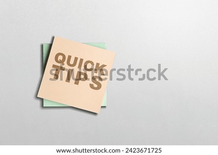 Stack of note paper with 'Quick tips' text on a white background. Tips and advice concept
