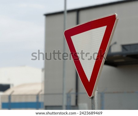 Selective focus photo of a Yield (give way priority) road sign with a blurry background