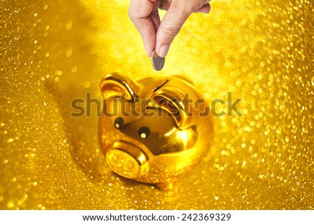 Saving money by gold piggy bank