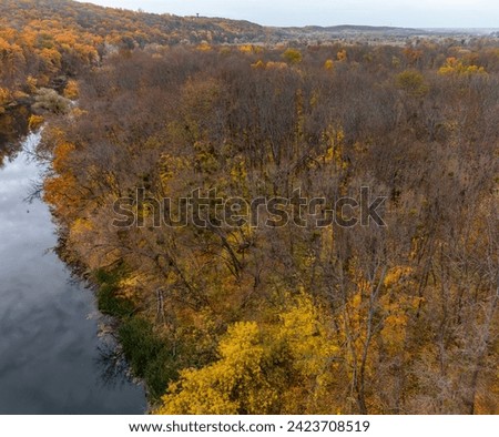 Aerial autumn river landscape and cloudy sky. Wild colorful autumnal riverside nature in Ukraine