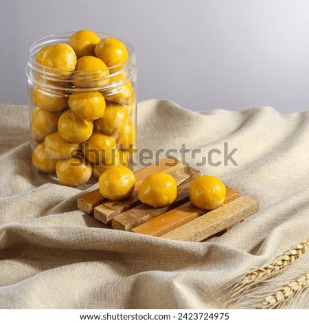 Nastar cookies are round in shape, with a shiny yellow top.  Inside it is filled with pineapple jam Royalty-Free Stock Photo #2423724975