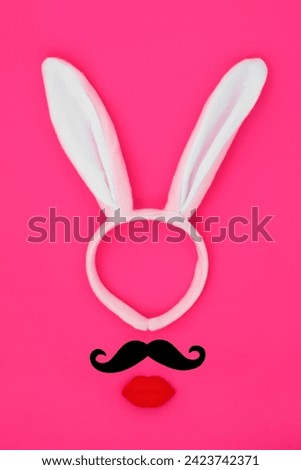 Easter bunny ears headband with pouting lips and mustache on vivid pink background. Abstract surreal minimal face design for the holiday season.
