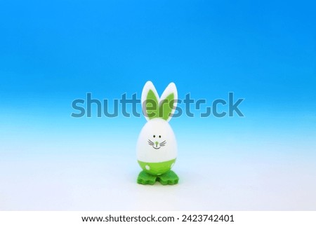 Easter bunny green egg on gradient blue white background. Minimal cute composition with environmentally friendly solitary theme.