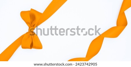 Satin ribbon bow for gift package in yellow color, isolated on white background.