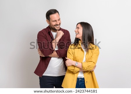 Romantic young boyfriend and girlfriend smiling and looking at each other over white background