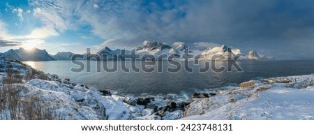 Panorama with Øyfjorden,  the snowy mountains from Senja, named Segla, Kongan and Skultran. interesting winter mood with blue and cloudy sky and steep rocky mountains in Norway Royalty-Free Stock Photo #2423748131