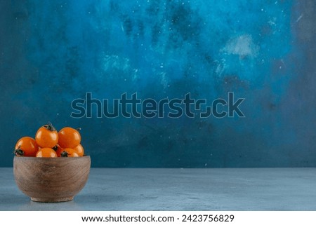 Cherry tomatoes in a cup on blue background. High quality photo