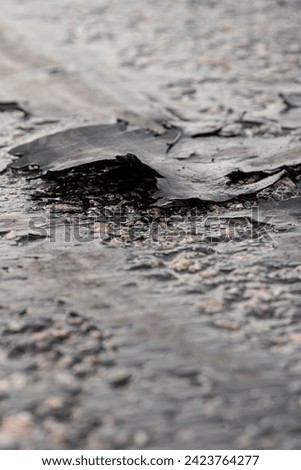 A piece of a car tire on a racing tracer. Pieces of car tires on an asphalt surface with sliding tracks. Traces of drifting cars on the surface of a racing track.