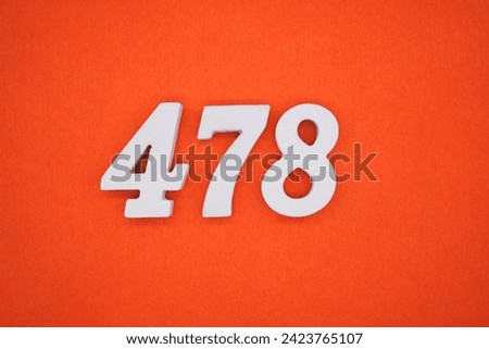 Orange felt is the background. The numbers 478 are made from white painted wood. Royalty-Free Stock Photo #2423765107
