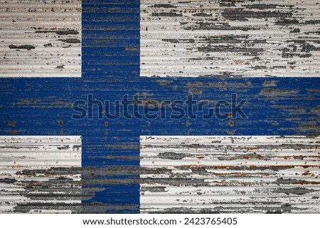 Close-up of old metal wall with national flag of Finland. Concept of Finland  export-import, storage of goods and national delivery of goods. Flag in grunge style