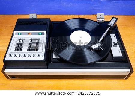 Vintage turntable vinyl record player with black vinyl on a table