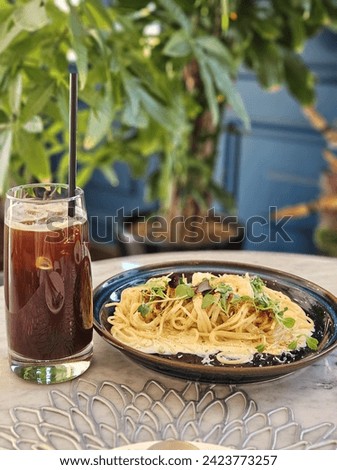 A picture of cream pasta and iced americano food