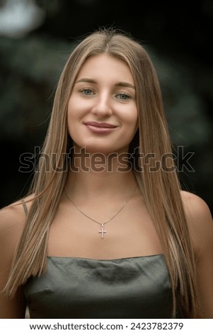 Portrait of a young beautiful blonde girl in a city summer park.