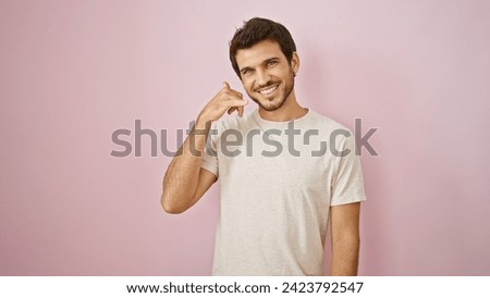 Smiling young hispanic man with beard making call me gesture against a pink isolated background Royalty-Free Stock Photo #2423792547