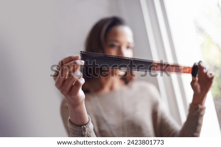 Woman, photographer and film negative for creative prints at window for sun or retro images for job, inspiration or hobby. Female person, artistic and roll for picture development, photoshoot or job