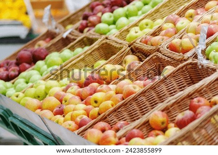 Stunning arrangement apples showcased in beautiful wicker baskets, ready for sale. Royalty-Free Stock Photo #2423855899