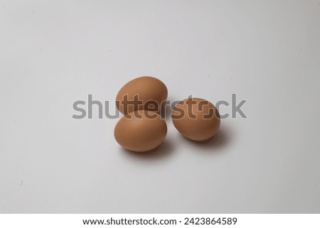 picture of three brown eggs on white background.