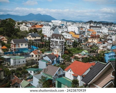 High angle view from drone of DALAT city at Vietnam. View over a city with multi coloured houses and shops. Agricultural land outside Dalat in the Central highlands of Vietnam on a sunny day. 