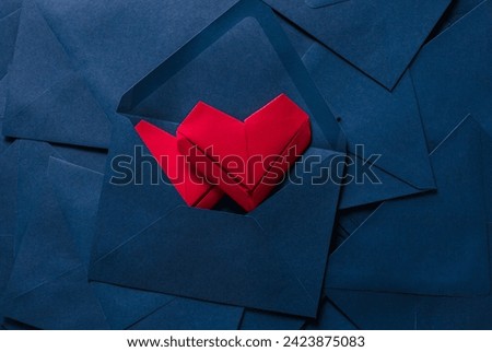 Envelopes and paper hearts,red folded paper heart,Red paper heart and blue envelope,Love letter idea with blue envelope with red hearts spilling out.