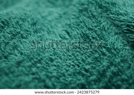 detailed texture of the soft fiber towel which is green and looks elegantly wavy. texture, background