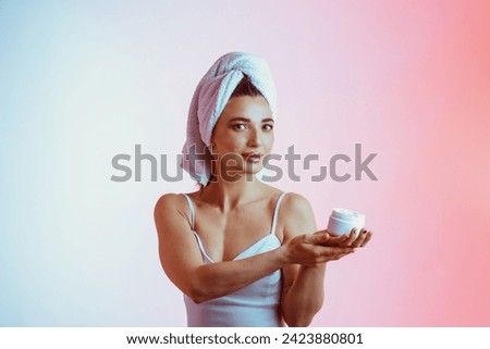 a young girl applying cream to her face and neck. bone procedures, rejuvenation, skin care . High quality photo
