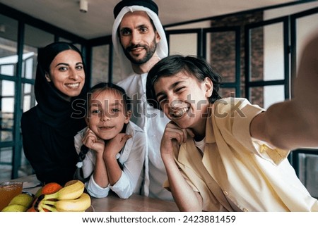 Traditional arabian family from Dubai spending time together at home. Concept about, emirati culture, parenthood, adoption and  family lifestyle Royalty-Free Stock Photo #2423881459