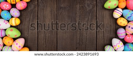 Colorful Easter Egg double border over a dark wood banner background. Copy space.