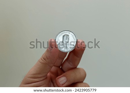 swiss five franc coin between fingers - swiss franc coin Royalty-Free Stock Photo #2423905779